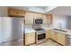 Close-up of a well-equipped kitchen featuring stainless steel appliances, light wood cabinets, and marble countertops at 8070 W Russell Rd # 1046, Las Vegas, NV 89113