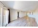 Open living space features wood flooring, a sliding glass door, and an adjacent kitchen area at 8070 W Russell Rd # 1046, Las Vegas, NV 89113