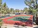 Community tennis court with green playing surface surrounded by a red border and chain link fence at 8070 W Russell Rd # 1046, Las Vegas, NV 89113