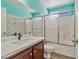 Bathroom featuring a combination shower-tub with glass doors, modern vanity, and tile accents at 8509 W Rochelle Ave, Las Vegas, NV 89147