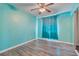 Vibrant bedroom with wood-look flooring, a ceiling fan, and a sliding mirror closet at 8509 W Rochelle Ave, Las Vegas, NV 89147
