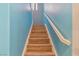 Bright, modern staircase with wood steps and a handrail, enhanced by vibrant blue walls at 8509 W Rochelle Ave, Las Vegas, NV 89147