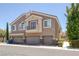 Inviting townhome featuring attached garages, tan stucco, and a charming balcony with a metal railing at 8639 Horizon Wind Ave # 102, Las Vegas, NV 89178