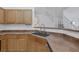 A stainless steel kitchen sink with light wood cabinets, white walls, and open staircase at 8639 Horizon Wind Ave # 102, Las Vegas, NV 89178