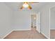 Unfurnished bedroom has neutral walls and carpet, with a ceiling fan and open door at 9044 Blue Raven Ave # R, Las Vegas, NV 89143