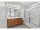 Well-lit bathroom features dual sinks, large mirror, and a glass-enclosed shower/tub at 9644 Flying Eagle Ln, Las Vegas, NV 89123