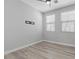 Bright bedroom featuring wood-look floors, ceiling fan, and light gray walls at 9644 Flying Eagle Ln, Las Vegas, NV 89123