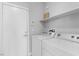 A bright laundry room featuring modern appliances, shelving, and security system at 9644 Flying Eagle Ln, Las Vegas, NV 89123