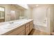 Bright bathroom featuring a double sink vanity, bathtub, and separate shower at 1012 Collingtree St, Las Vegas, NV 89145
