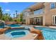 Inviting pool and spa with rock features, complemented by an outdoor seating area and patio at 1016 Sable Mist Ct, Las Vegas, NV 89144