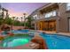 A stunning backyard pool with waterfall features, rock accents, and spa under sunset sky at 1016 Sable Mist Ct, Las Vegas, NV 89144