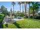 Private backyard with a sparkling pool, manicured lawn, and a charming outdoor dining setup under the palms at 10320 Luxembourg Ave, Las Vegas, NV 89145
