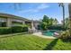 Inviting backyard oasis with green grass, a refreshing pool, and an outdoor dining area under the sun at 10320 Luxembourg Ave, Las Vegas, NV 89145