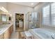 Luxurious bathroom with a soaking tub, glass-enclosed shower, and walk-in closet at 10320 Luxembourg Ave, Las Vegas, NV 89145