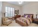 Cozy bedroom with shutters, a wooden bed frame, and dresser with warm lamps and decor at 10320 Luxembourg Ave, Las Vegas, NV 89145