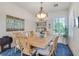 Elegant dining room featuring a decorative chandelier, blue rug, and bright, natural lighting at 10320 Luxembourg Ave, Las Vegas, NV 89145