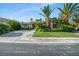 Charming single story home with lush landscaping, mature palm trees, and a spacious driveway at 10320 Luxembourg Ave, Las Vegas, NV 89145