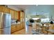 Open kitchen view with tile flooring, stainless steel refrigerator, oak cabinetry, and seamless transition to the living area at 10320 Luxembourg Ave, Las Vegas, NV 89145