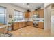 Bright eat-in kitchen featuring wooden cabinetry, stainless steel appliances, tile flooring, and large window at 10320 Luxembourg Ave, Las Vegas, NV 89145