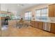 Open kitchen and breakfast nook combination offering wooden cabinetry, tile flooring, and lots of natural light at 10320 Luxembourg Ave, Las Vegas, NV 89145