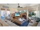 Spacious living room with a cozy fireplace, large windows, and beautiful decor with a ceiling fan at 10320 Luxembourg Ave, Las Vegas, NV 89145