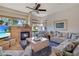 Bright living room features a cozy fireplace, large windows, ceiling fan and plush seating for comfortable living at 10320 Luxembourg Ave, Las Vegas, NV 89145