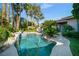 Beautiful backyard pool and patio surrounded by lush landscaping, palm trees, and an outdoor seating area at 10320 Luxembourg Ave, Las Vegas, NV 89145