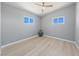 This bedroom features two windows, light wood floors, and neutral-painted walls at 104 Stanford St, Las Vegas, NV 89107