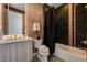 Bathroom featuring black tile, soaking tub, and wood grain vanity at 10752 Patina Hills Ct, Las Vegas, NV 89135