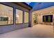 Exterior showcasing modern architecture, expansive windows, and tiled patio at 10752 Patina Hills Ct, Las Vegas, NV 89135