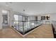 Second story hallway with hardwood flooring and modern chandelier with glass railings at 10752 Patina Hills Ct, Las Vegas, NV 89135
