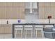 Modern kitchen features a breakfast bar with seating, light cabinetry, and stone countertops at 10752 Patina Hills Ct, Las Vegas, NV 89135