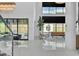 Bright living room with soaring ceilings, modern decor, and expansive windows overlooking the backyard at 10752 Patina Hills Ct, Las Vegas, NV 89135