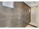 Walk-in shower features rainfall showerhead, wood tile accent wall and niche for storage at 10752 Patina Hills Ct, Las Vegas, NV 89135