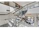 Modern staircase with glass railings, and wood accents, leading to an open living space at 10752 Patina Hills Ct, Las Vegas, NV 89135