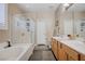 Well-lit bathroom features a separate tub and shower, double sinks, and neutral decor, creating a clean and inviting space at 1076 Crescent Falls St, Henderson, NV 89011