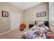 Comfortable bedroom featuring a bed with unique bedding, basketball-themed chair and a closet at 1076 Crescent Falls St, Henderson, NV 89011