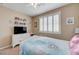 Bright bedroom features a bed with colorful bedding, dresser, and a window with shutters at 1076 Crescent Falls St, Henderson, NV 89011