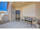 Cozy front porch with black front door, adorned with an iron bench and potted plants at 1076 Crescent Falls St, Henderson, NV 89011