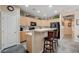 Kitchen featuring a breakfast bar, light wood cabinets, and black appliances at 1076 Crescent Falls St, Henderson, NV 89011