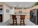 Kitchen featuring light wood cabinets, black appliances, and a breakfast bar for casual dining at 1076 Crescent Falls St, Henderson, NV 89011