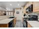 Kitchen with light cabinets, stainless steel sink, and black appliances at 1076 Crescent Falls St, Henderson, NV 89011