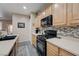 Kitchen featuring light wood cabinets, black appliances, and a modern backsplash design at 1076 Crescent Falls St, Henderson, NV 89011