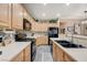 Well-lit kitchen showcasing light wood cabinets, black appliances, and modern countertops at 1076 Crescent Falls St, Henderson, NV 89011