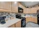 Kitchen with light wood cabinets, black appliances, and a modern backsplash at 1076 Crescent Falls St, Henderson, NV 89011