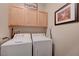 Bright laundry area with upper cabinets and side by side washer and dryer at 1076 Crescent Falls St, Henderson, NV 89011