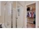 Bathroom shower with glass doors, integrated shelving, and a view into the walk-in closet, maximizing space and functionality at 1076 Crescent Falls St, Henderson, NV 89011