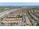 Expansive aerial view showcases the community's layout with a variety of houses and a nearby highway at 11253 Revelry Ln, Las Vegas, NV 89138