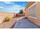 An empty backyard features a concrete patio and a gravel area, all enclosed by a brick wall at 11253 Revelry Ln, Las Vegas, NV 89138