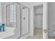Modern bathroom with glass shower, soaking tub, and an open door to a closet at 11253 Revelry Ln, Las Vegas, NV 89138